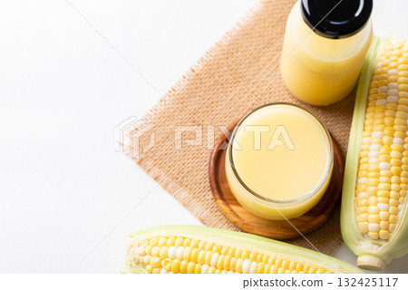 Sweetcorn milk in glass and bottle with fresh sweetcorn, Alternative milk from plant, dairy free Sweetcorn milk in glass and bottle with fresh sweetcorn, Alternative milk from plant, dairy free 132425117
