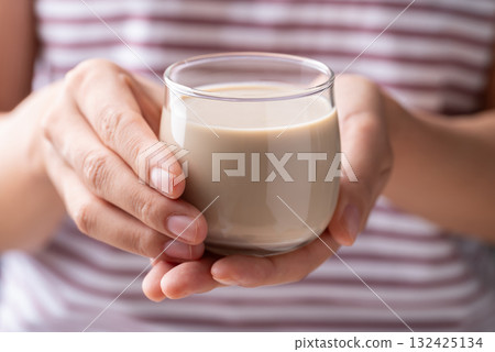 Pistachio milk in glass holding by woman hand, Alternative milk made from plant, Dairy free 132425134