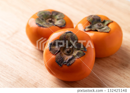 Ripe persimmon fruit on wooden background, Autumn fruit 132425148