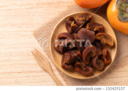 Dried persimmon on wooden plate ready to eating, Sweet and chewy, Table top view Dried persimmon on wooden plate ready to eating, Sweet and chewy, Table top view 132425157