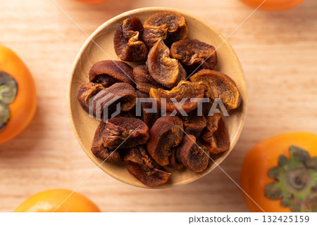 Dried persimmon on wooden plate ready to eating, Sweet and chewy, Table top view Dried persimmon on wooden plate ready to eating, Sweet and chewy, Table top view 132425159