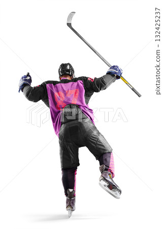 Hockey player in action. Hockey champion seen rear view. A very emotional hockey player with a stick and puck in his hands. Isolated. Sports emotions 132425237