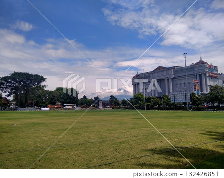 Large Green Field with Neoclassical Government Building Under Blue Sky 132426851