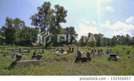 Traditional Indonesian Muslim Cemetery with Tombstones and Green Trees 132426857