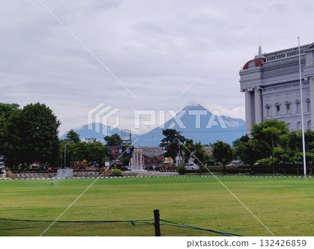 Volcano View from City Square with Classical Building and Green Field 132426859
