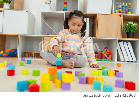 toddler girl playing block toy to stacks building cubes at home 132426908