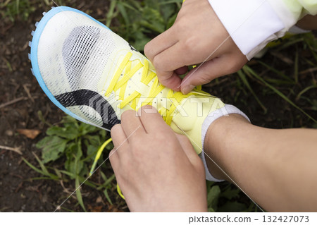 Male hand wearing a shoelace Male hand wearing a shoelace 132427073