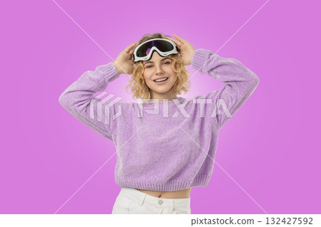 Cheerful woman in ski goggles and a purple sweater 132427592