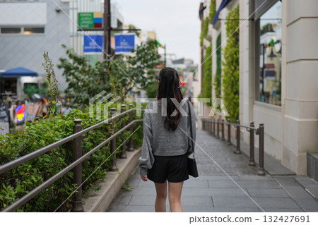 一名女子走在原宿商業區的街道上的背影 一名女子走在原宿商業區的街道上的背影 132427691