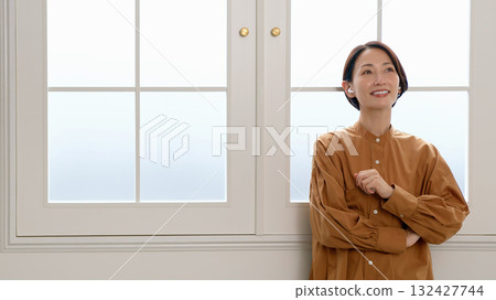 一位女士在窗邊聽音樂或聽收音機 132427744