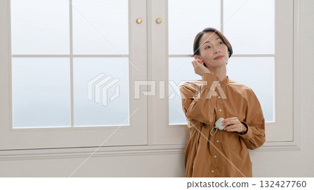 一位女士在窗邊聽音樂或聽收音機 132427760