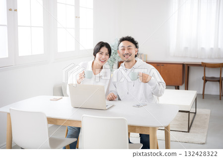 A couple looking at the camera in a beautiful living room. An image of a happy marriage. A couple looking at the camera in a beautiful living room. An image of a happy marriage. 132428322