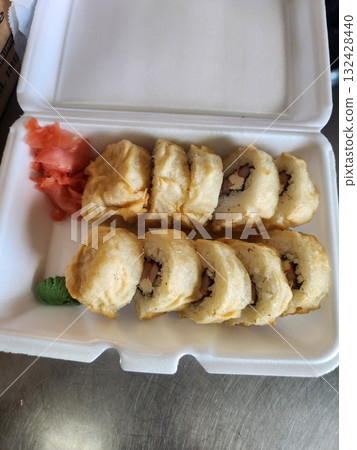 Delicious Sushi Rolls With Drizzled Sauce, Pickled Ginger, and Wasabi in Takeout Box 132428440