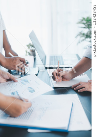Business teamwork reviewing financial report with charts and graphs in modern office, colleagues discussing analysis, planning strategy, growth and corporate success with documents and technology. 132428455