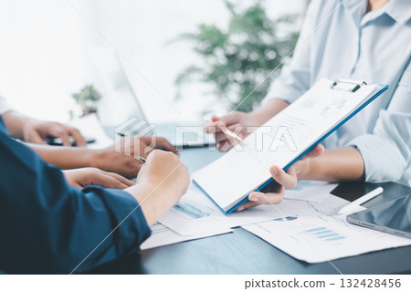 Business teamwork reviewing financial report with charts and graphs in modern office, colleagues discussing analysis, planning strategy, growth and corporate success with documents and technology. Business teamwork reviewing financial report with charts and graphs in modern office, colleagues discussing analysis, planning strategy, growth and corporate success with documents and technology. 132428456
