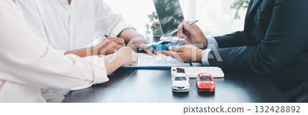 Panorama view of car loan agreement signing with dealer presenting vehicle model, customer using calculator at office desk, concept of auto finance, leasing, insurance and business contract. 132428892