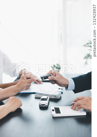 Customer signing car loan contract with dealer showing vehicle model, concept of auto finance, leasing, insurance or purchase agreement, business negotiation and financial planning. auto finance. 132428937
