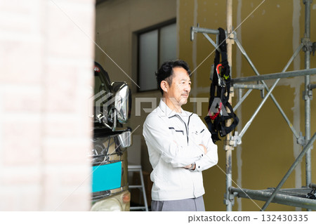 Middle-aged man posing in front of a truck Construction image 132430335