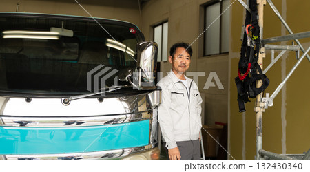 一名中年男子在卡車前擺姿勢的施工影像 一名中年男子在卡車前擺姿勢的施工影像 132430340