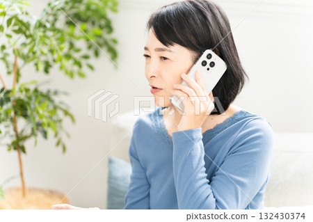 一位中年婦女在智慧型手機上交談的生活方式形象 132430374