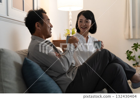 Middle-aged couple drinking beverages from mugs Lifestyle image 132430404