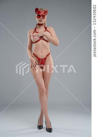 Woman poses confidently in leather belts in modern studio setting Woman poses confidently in leather belts in modern studio setting 132430682