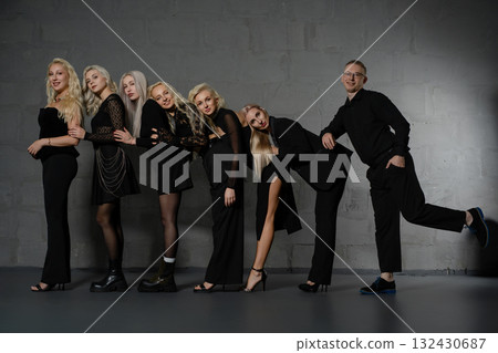 Group of fashionably dressed individuals posing together in a studio setting 132430687
