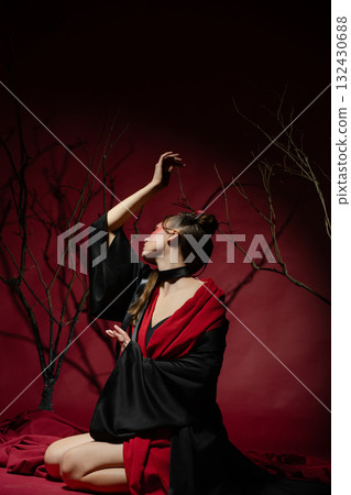 Woman poses elegantly in traditional Japanese attire within a studio setting Woman poses elegantly in traditional Japanese attire within a studio setting 132430688