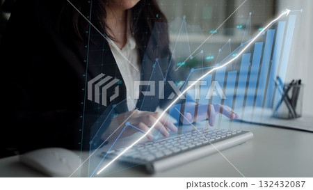 Professional business woman analyzes financial data using digital graphs and charts on computer, focusing on trends and growth projections in a modern office Copula 132432087