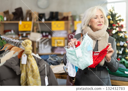 Positive mature woman choosing red panties in clothing store Positive mature woman choosing red panties in clothing store 132432783