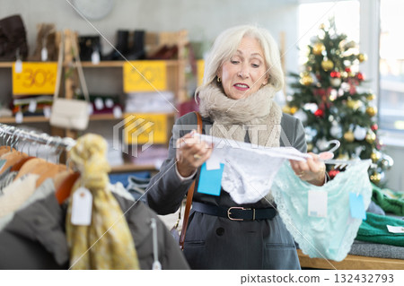 Positive mature woman choosing panties in clothing store Positive mature woman choosing panties in clothing store 132432793