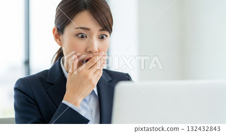 一名日本女員工對電腦螢幕感到驚訝 一名日本女員工對電腦螢幕感到驚訝 132432843