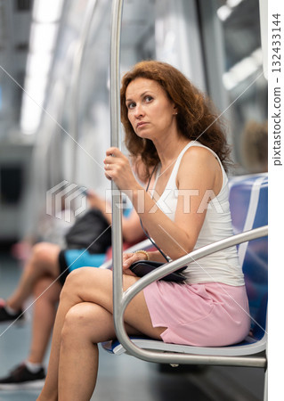 Adult woman sitting in subway car 132433144