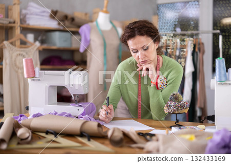 Sad female tailor businesswoman examines documents 132433169