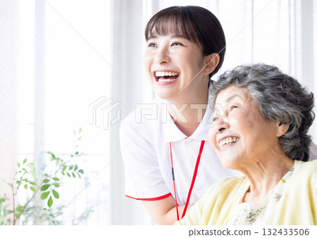 A young caregiver assisting a patient at a nursing home A young caregiver assisting a patient at a nursing home 132433506