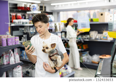 Teenage boy choosing canned dog food for Yorkshire terrier at pet store Teenage boy choosing canned dog food for Yorkshire terrier at pet store 132433653