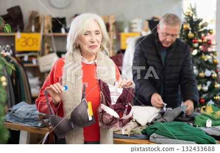 Mature woman chooses bra in fashionable clothing boutique 132433688