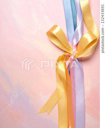 Pale shiny colorful satin ribbons tied on a pastel background 132433691