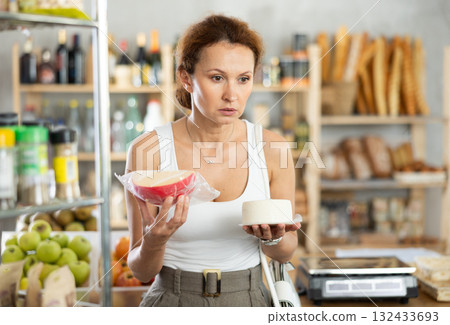 Adult woman choosing cheese in grocery store 132433693