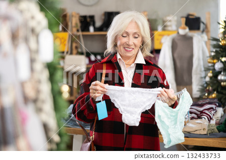 Mature woman choosing panties in the store against the background of the Christmas tree 132433733