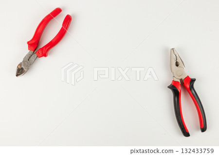 Two pairs of pliers on a clean work surface in a well-lit area 132433759