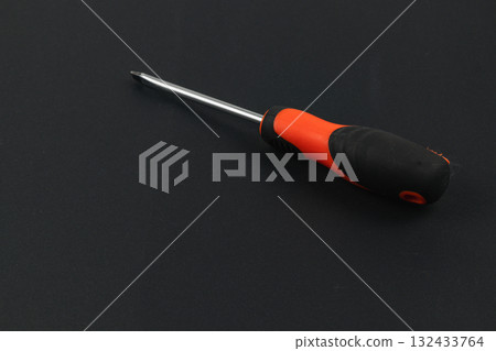 Screwdriver with ergonomic handle on a black background Screwdriver with ergonomic handle on a black background 132433764