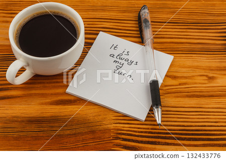 Coffee cup and note on wooden table conveying a motivational message Coffee cup and note on wooden table conveying a motivational message 132433776