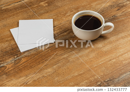 Coffee cup on wooden table with blank notes in a cozy setting Coffee cup on wooden table with blank notes in a cozy setting 132433777