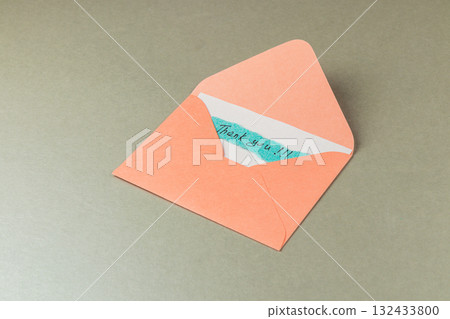 Thank you card inside a colorful envelope on a neutral background 132433800