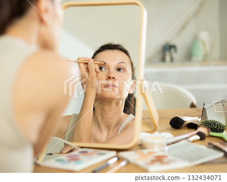 Woman using eyebrow brush during daily beauty routine Woman using eyebrow brush during daily beauty routine 132434071