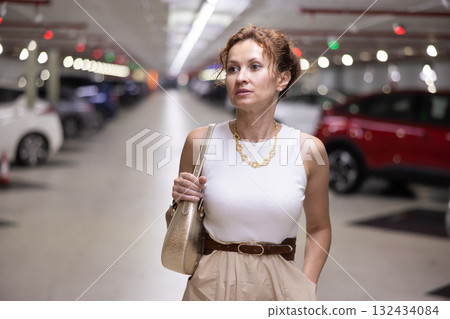 Adult woman standing in parking lot 132434084