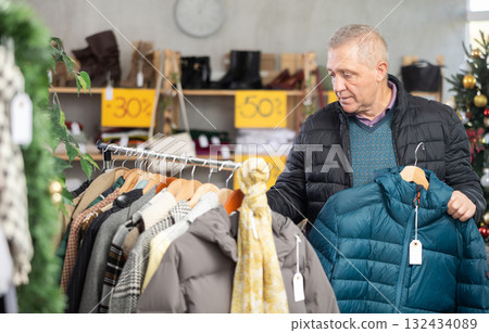 Attentive mature man choosing jacket in clothing store Attentive mature man choosing jacket in clothing store 132434089