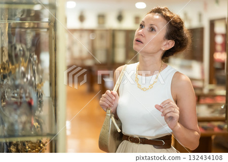 Woman visit museum, examines masterpiece at exhibition Woman visit museum, examines masterpiece at exhibition 132434108