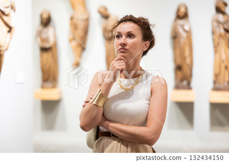 Woman visit museum, examines masterpiece at exhibition 132434150